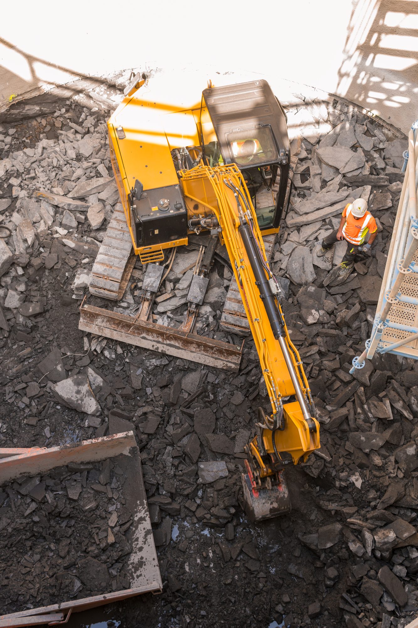 Bagger mit Hydraulikhammer beim Aufstemmen der Betonsohle